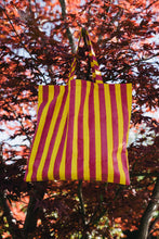 Load image into Gallery viewer, pink and yellow striped William block print bag hanging in an acer tree
