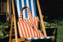 Load image into Gallery viewer, pink and yellow striped William block print bag on a blue striped deckchair
