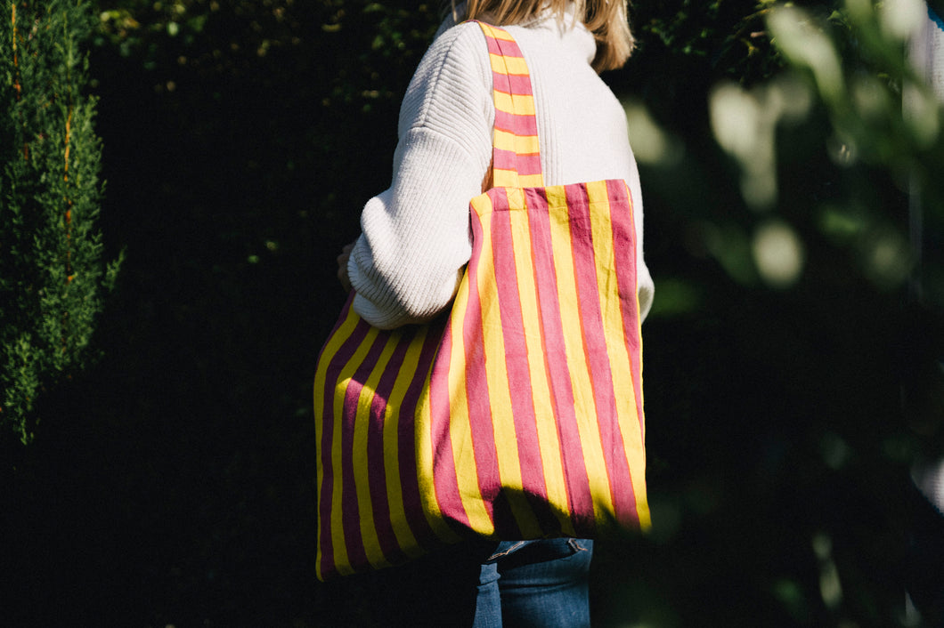 pink and yellow striped William block print bag on a girl's shoulder
